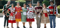 A group of people in traditional attire standing together outside.